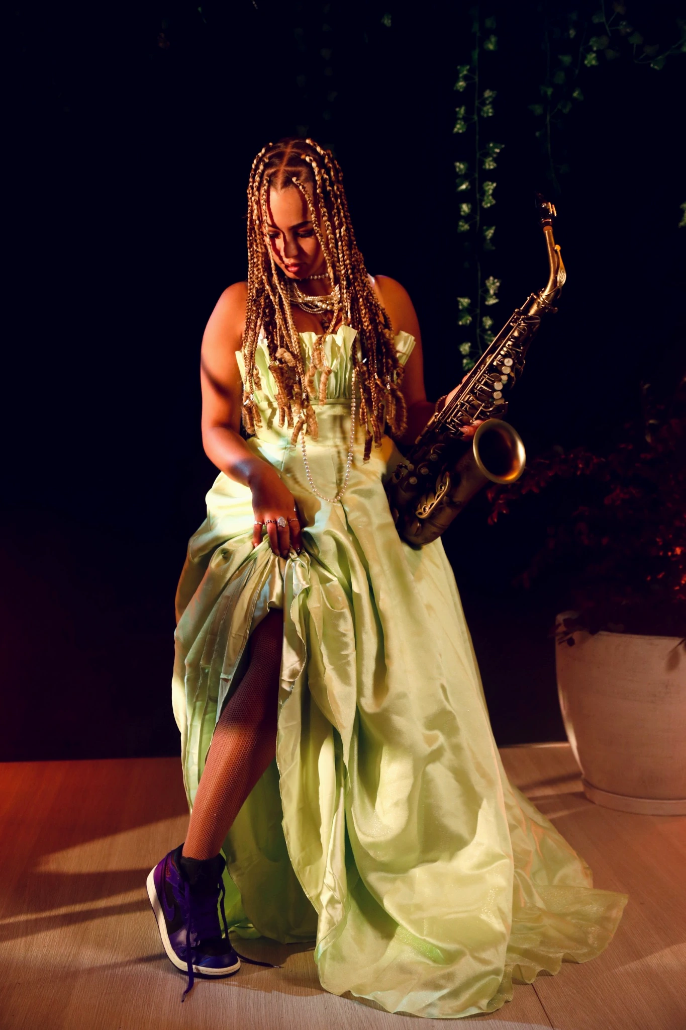 Kassandra holding a saxophone in a full-length artist portrait